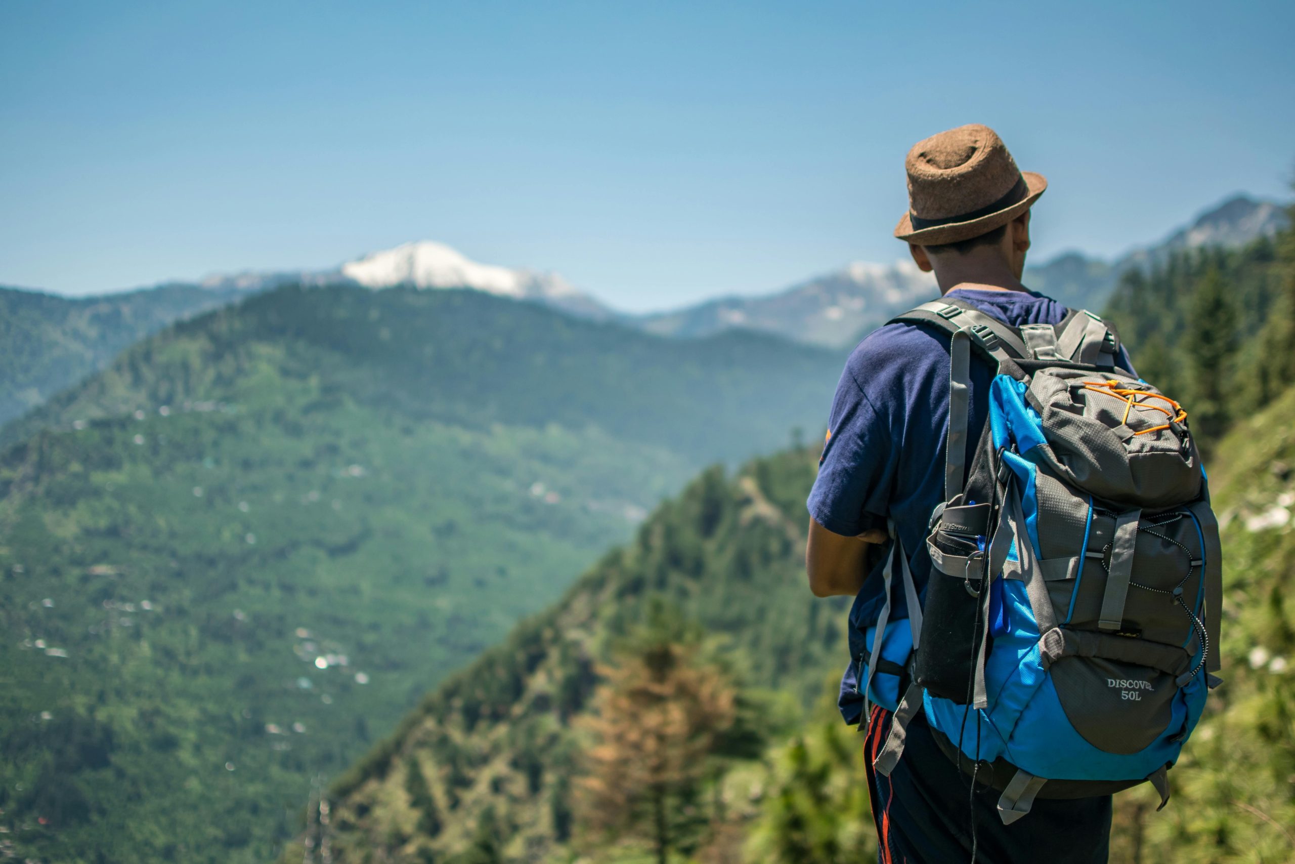 A hiker consulting their smartwatch before starting a trek up a snowy hill.