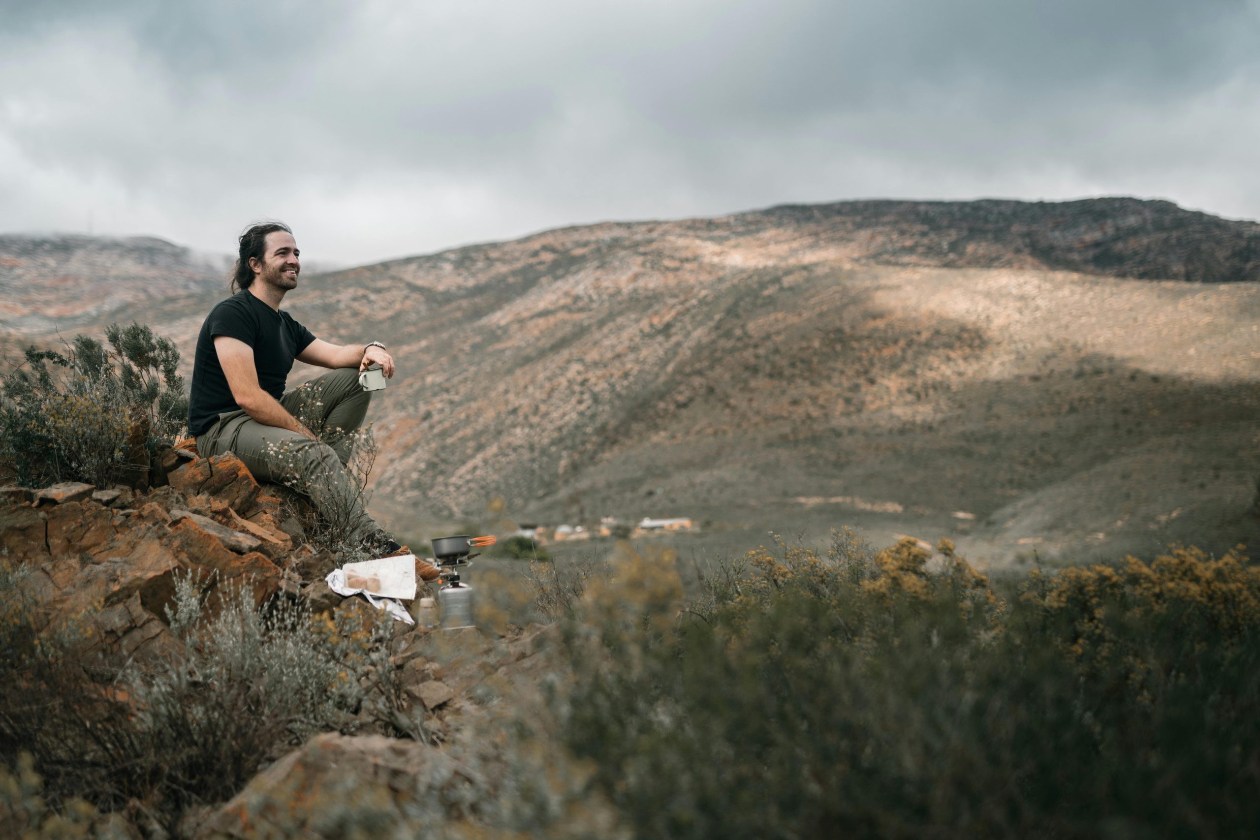 Hiker adjusting settings on their smartwatch beside a scenic mountain view
