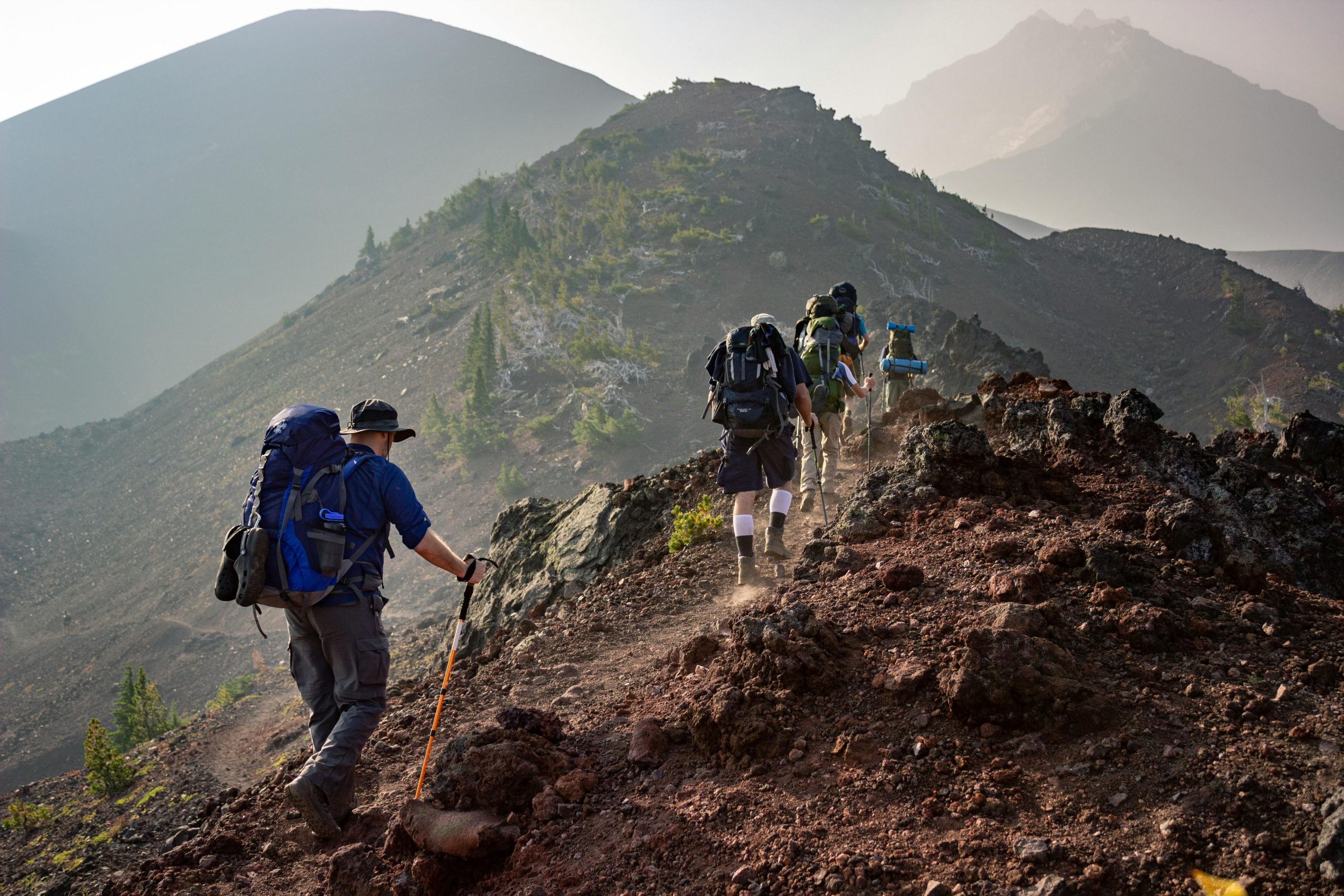 Hikers near a marked trailhead displaying the exact altitude on a plaque.