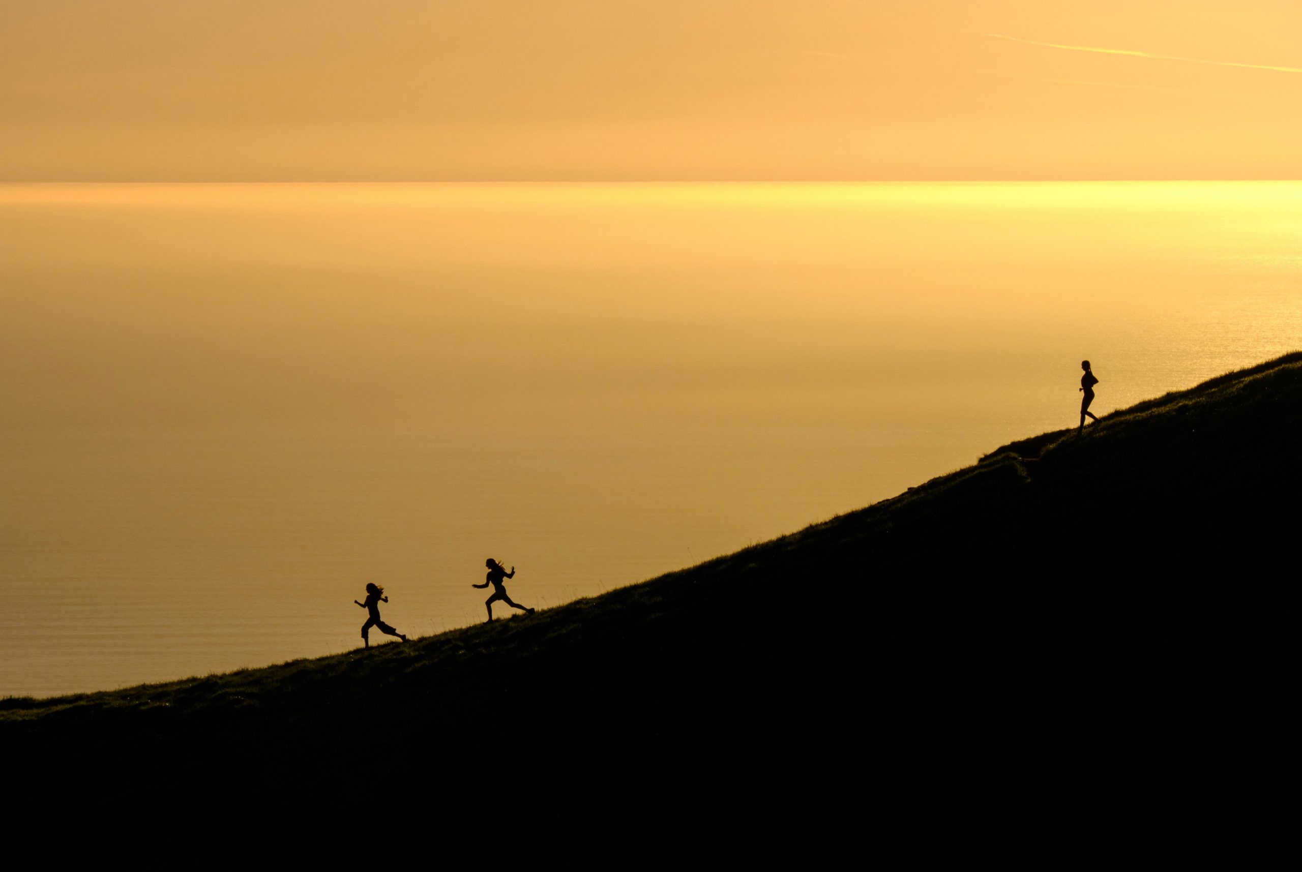 A hiker checking their smartwatch while standing near a cliff edge.