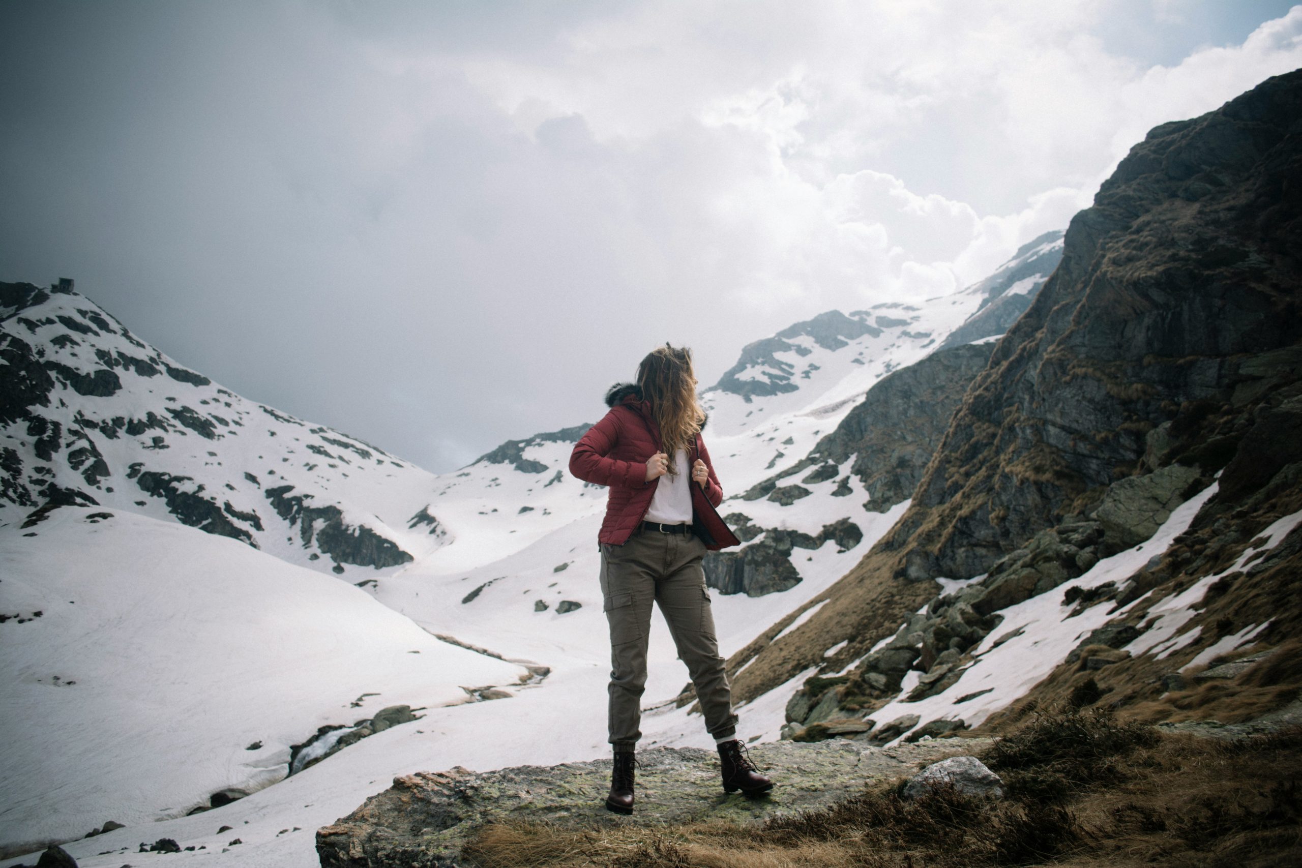A hiker wearing a smartwatch with an altimeter feature checks elevation while climbing a mountain