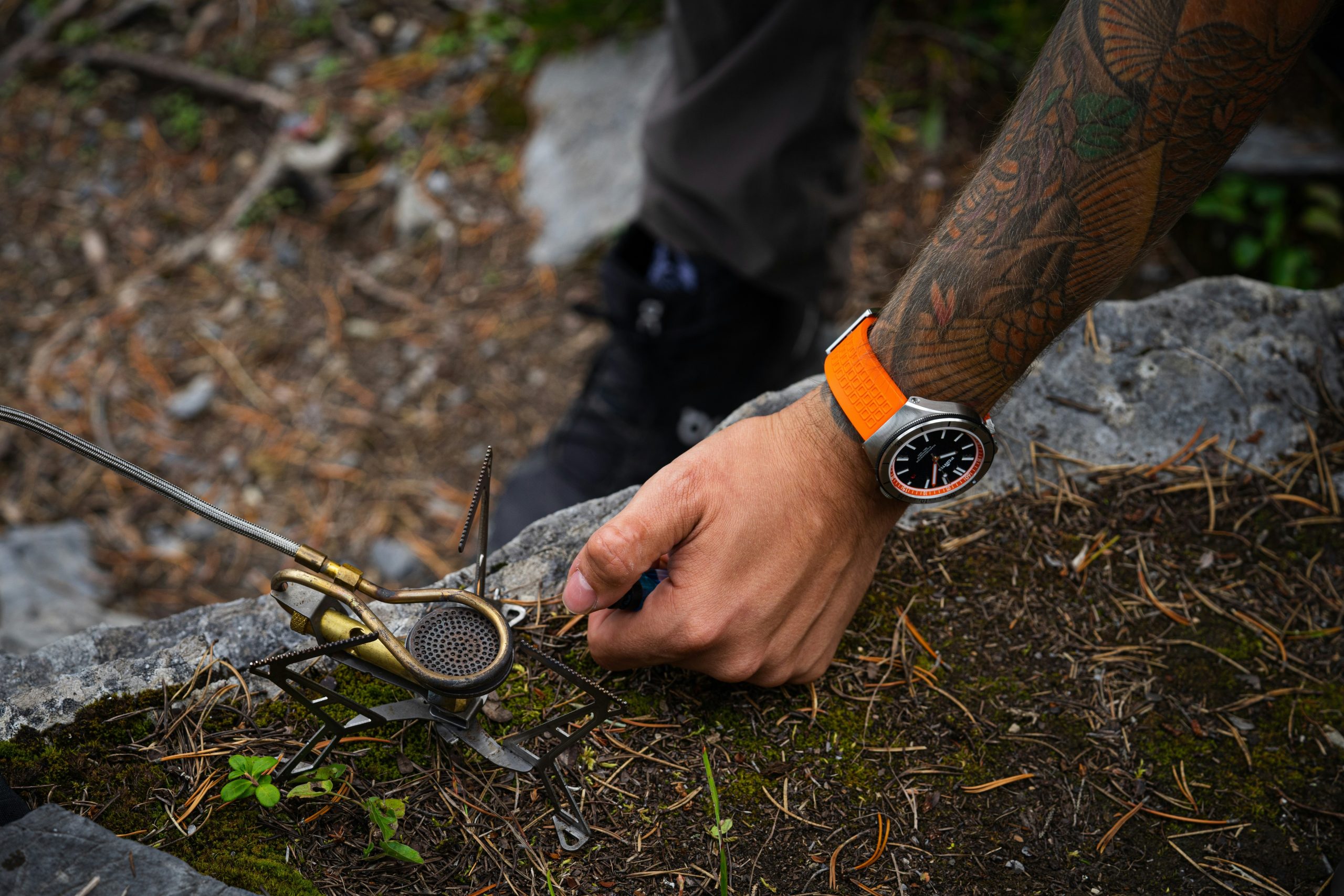 A hiker wearing a watch altimeter while checking their elevation on a rugged mountain path