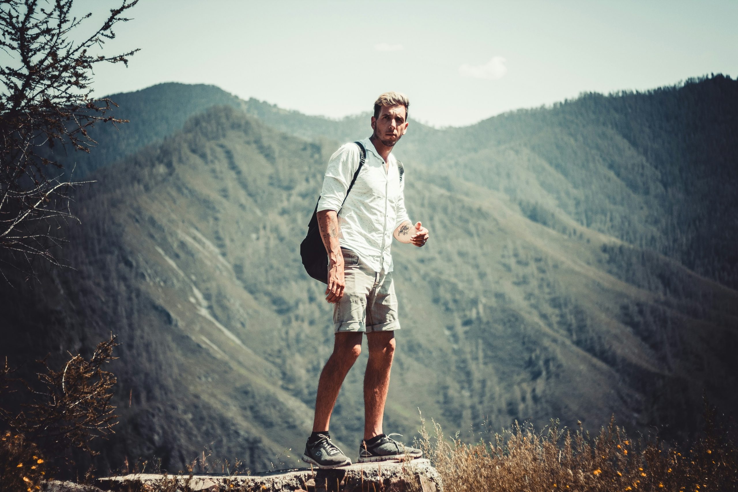 Man standing on a mountain trail looking at his smartwatch