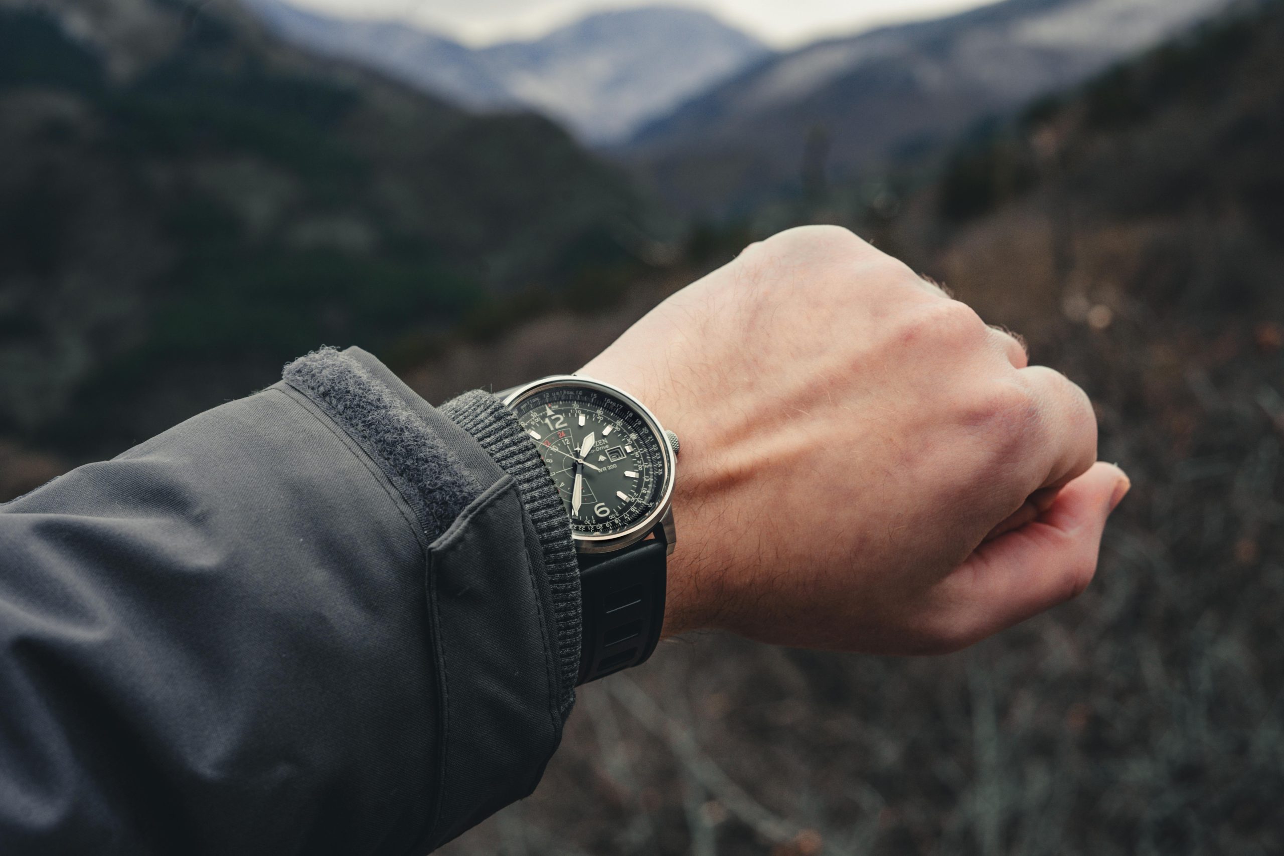 Person wearing a rugged watch altimeter while hiking uphill
