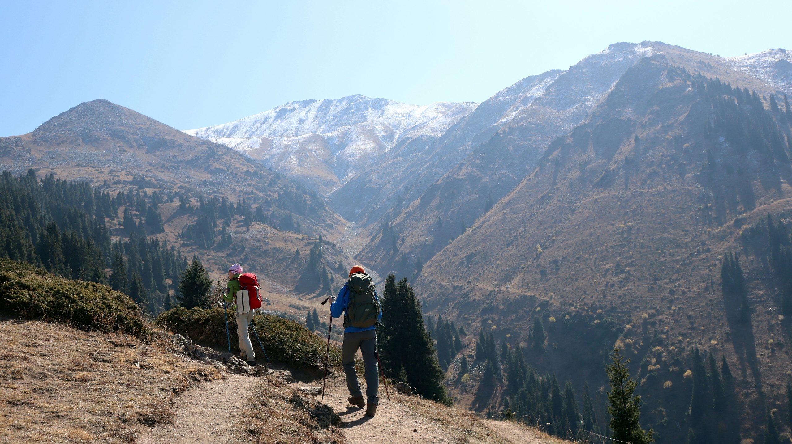 A hiker struggling to read an old paper map while standing on rocky terrain.