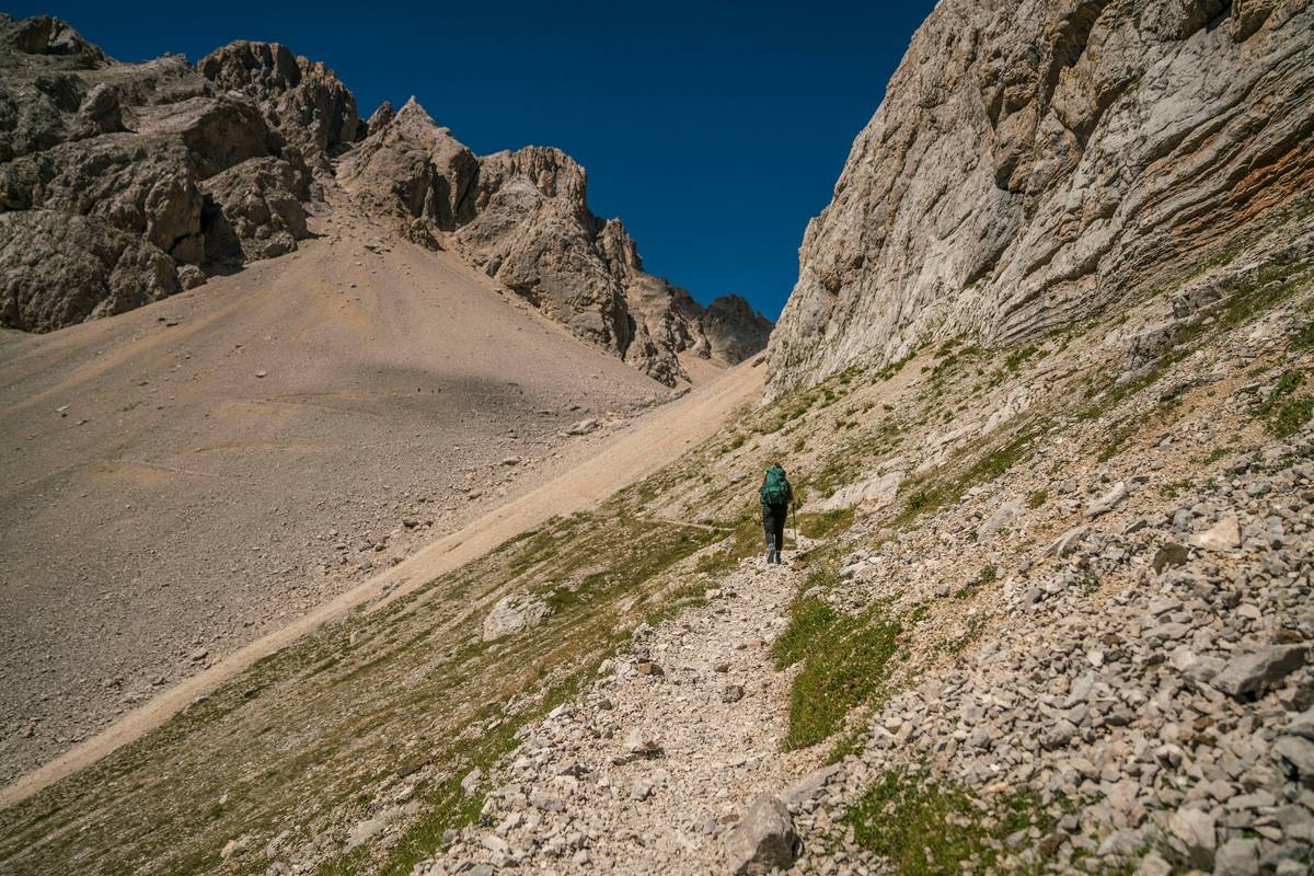 Hiker checking watch altimeter while ascending a misty trail