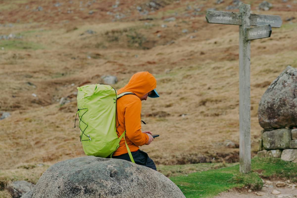 A hiker checking their altimeter watch on a rugged trail