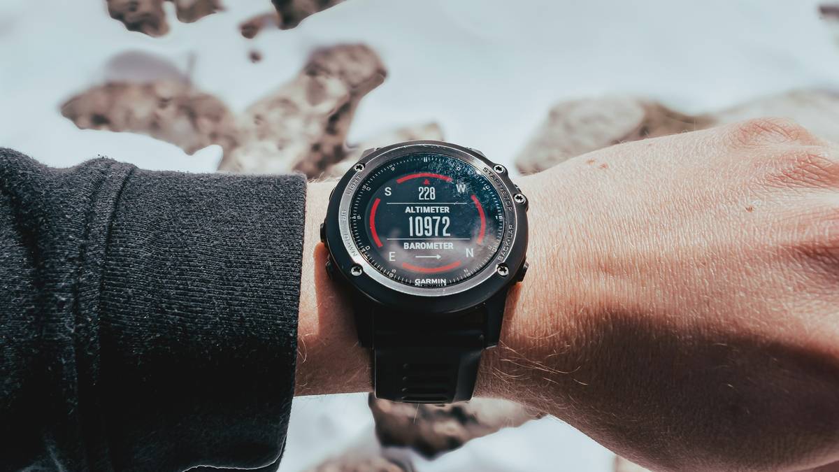 A solo hiker checking their smartwatch on a rugged trail.