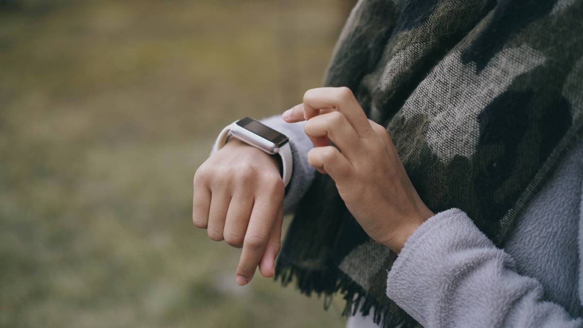Close-up shot of hikers wearing durable tech watches during challenging terrains.